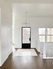 Foyer entrance with dark wood-type flooring and a notable chandelier