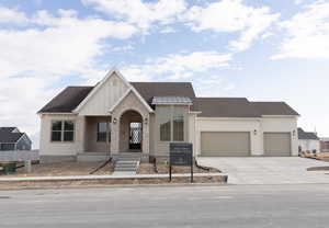 View of front facade featuring a garage and cooling unit