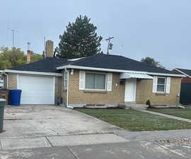 Ranch-style house featuring a garage and a front yard