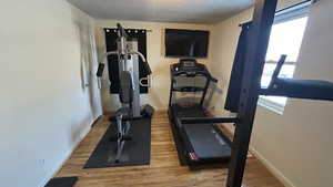 Exercise area with a textured ceiling, hardwood / wood-style floors, and plenty of natural light