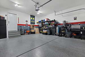 Garage with black refrigerator and a garage door opener