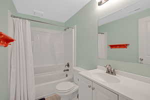 Full bathroom featuring toilet, vanity, and shower / tub combo with curtain