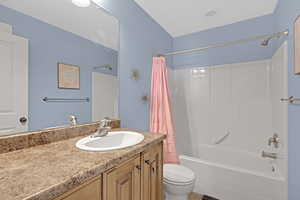 Full bathroom featuring toilet, vanity, and shower / tub combo