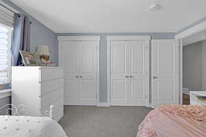 Carpeted bedroom with two closets