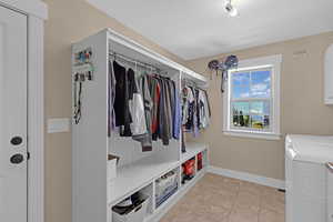 Mudroom with light tile patterned floors and washing machine and clothes dryer