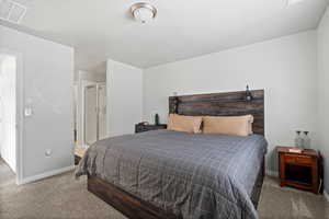 Bedroom featuring connected bathroom and carpet floors