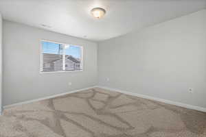 Carpeted spare room with a textured ceiling