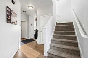 Stairway with a textured ceiling and hardwood / wood-style flooring