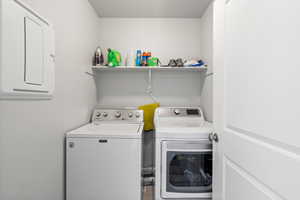 Laundry room featuring washing machine and clothes dryer and a textured ceiling