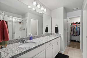 Bathroom featuring vanity, a textured ceiling, tile patterned floors, and an enclosed shower