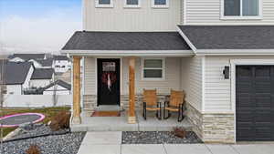 View of exterior entry with covered porch and a garage