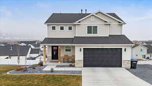 View of front of home with a front yard and a garage