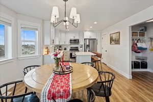 Dining space featuring sink, a chandelier, and light wood-type flooring