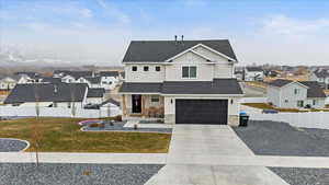 View of front of house featuring a garage and a front lawn