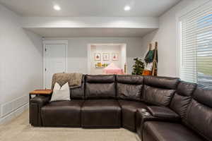 Living room featuring light colored carpet and plenty of natural light