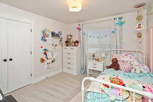 Bedroom featuring light carpet