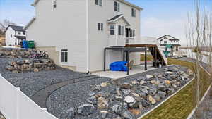 View of home's exterior featuring a playground, a patio area, and a wooden deck