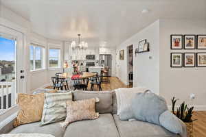 Living room featuring light wood-type flooring and an inviting chandelier