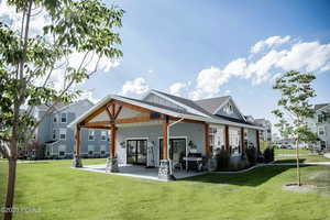 Rear view of house featuring a patio and a yard