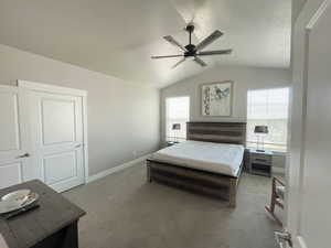 Bedroom featuring a textured ceiling, ceiling fan, lofted ceiling, and carpet floors