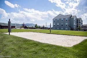 View of home's community featuring volleyball court and a lawn