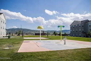 View of home's community featuring a mountain view, a lawn, and volleyball court