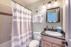 Full bathroom featuring shower / tub combo, vanity, and toilet