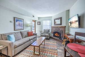 Living room with a fireplace and a textured ceiling