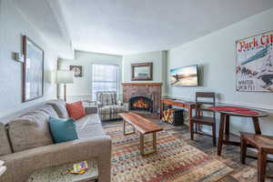 Living room with a textured ceiling and a brick fireplace