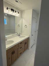 Bathroom featuring vanity, a bathing tub, and a textured ceiling