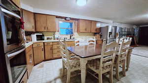Kitchen featuring a textured ceiling and stainless steel appliances