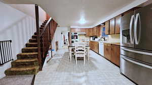 Kitchen featuring sink, a kitchen breakfast bar, appliances with stainless steel finishes, and a textured ceiling
