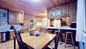 Tiled dining room featuring wooden ceiling