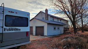 View of side of property with a garage and an outbuilding