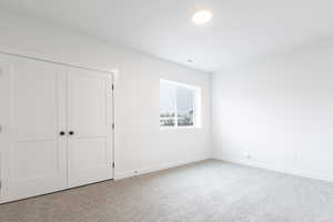 Unfurnished bedroom featuring a closet and carpet