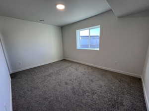 Unfurnished room featuring dark colored carpet