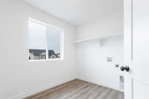 Laundry area featuring washer hookup, hookup for an electric dryer, and light hardwood / wood-style flooring