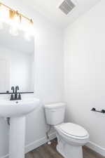 Bathroom featuring hardwood / wood-style flooring, sink, and toilet