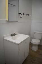 Bathroom with toilet, vanity, and hardwood / wood-style flooring