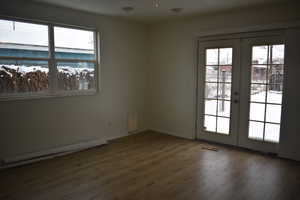 Spare room featuring french doors and dark hardwood / wood-style floors