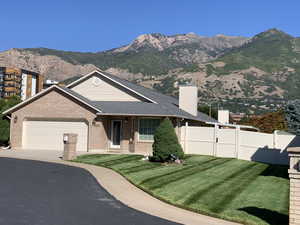 View of front facade with a mountain view, a front yard, and a garage