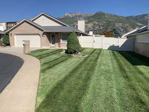 View of front facade with a front yard, a mountain view, and a garage