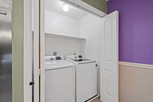 Washroom featuring independent washer and dryer and hardwood / wood-style flooring