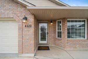 View of exterior entry with a garage