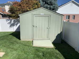 View of outbuilding featuring a mountain view and a lawn