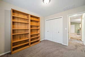 Unfurnished bedroom with carpet, a closet, and a textured ceiling