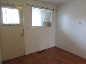 Doorway to outside featuring plenty of natural light and dark tile patterned floors