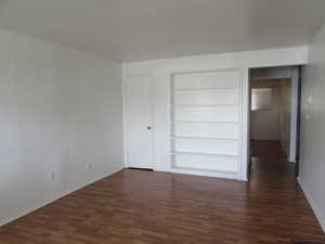 Unfurnished bedroom with a closet and dark hardwood / wood-style flooring