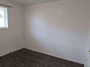 Unfurnished room featuring dark hardwood / wood-style flooring