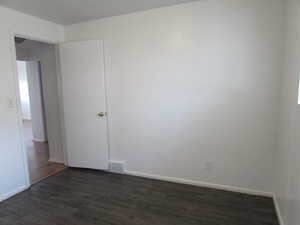 Unfurnished room featuring dark hardwood / wood-style floors